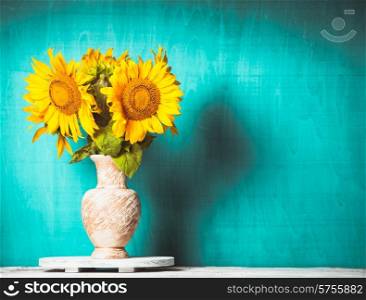 Sunflower in the vase over blue wooden background. Sunflower still life