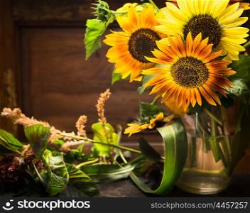 sunflowers in vase on table over wooden background, Still life