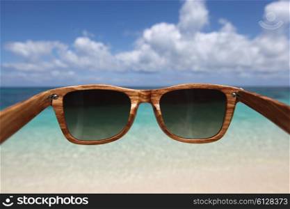 Sunglasses and sea beach. View through wooden sunglasses into tropical beach of Philippines