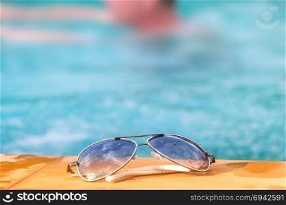 Sunglasses Near A Swimming Pool Showing Holiday