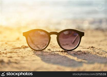 Sunglasses on beach summer background concept