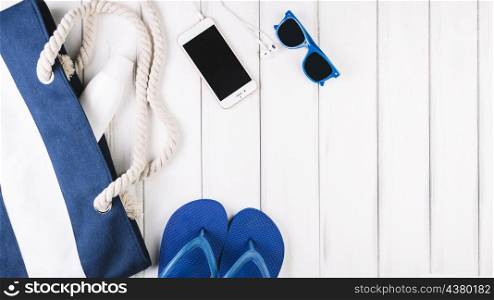 sunglasses smartphone near bag flip flops