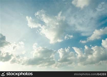 Sunlight and burst explode in cloudy blue sky clouds background
