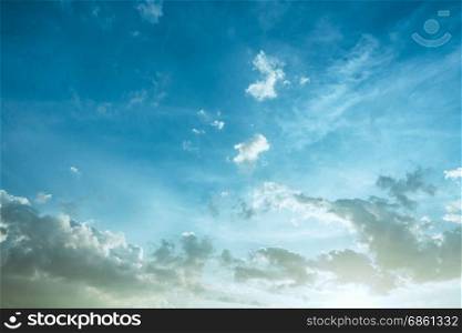 Sunlight and burst explode in cloudy blue sky clouds background