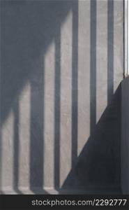 Sunlight and shadow of steel pipe of wall framework structure on loft cement wall surface inside of house construction site in vertical frame