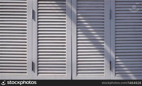 Sunlight and shadow on surface of the old vintage white wooden folding wall background