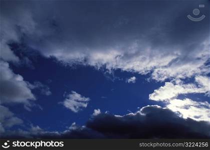 Sunlight Cutting Through Dark Clouds In A Blue Sky