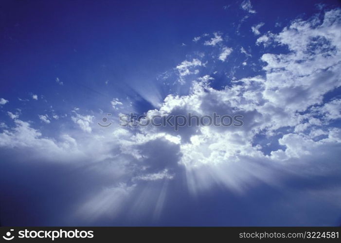 Sunlight Filtered Through Clouds In A Blue Sky