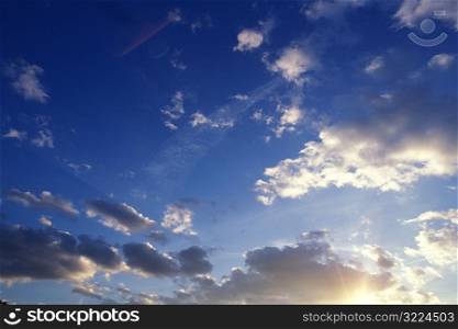 Sunlight Filtered Through Light And Dark Clouds In A Blue Sky