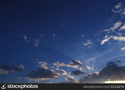 Sunlight Filtered Through Small Clouds In A Clear Blue Sky