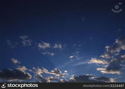 Sunlight Filtered Through Small Clouds In A Clear Blue Sky