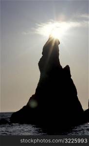 Sunlight Illuminating A Rocky Point In The Sea