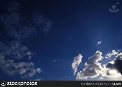 Sunlight Piercing Through Clouds In A Blue Sky