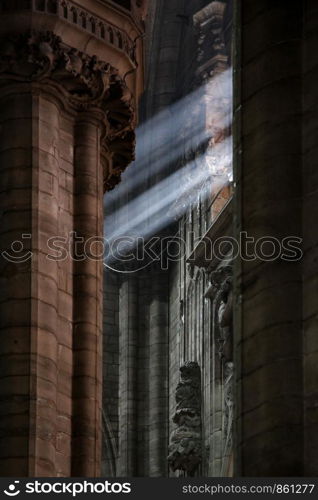 Sunlight shines with a beam of light in the dark cathedral