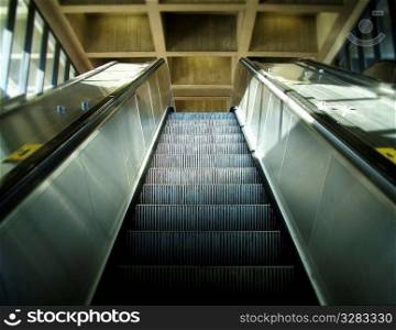 Sunlight shining on ascending metal escalator.