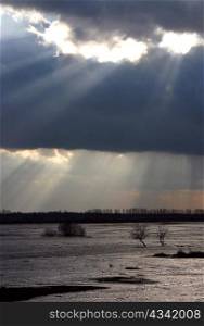 Sunlight that makes its way through the clouds over the river