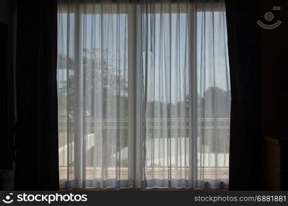 Sunlight through a thin curtain in the bedroom.