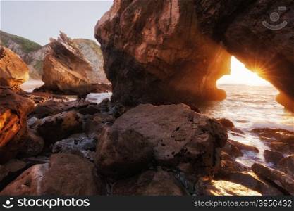Sunlight through rock arch, Ursa beach, Portugal