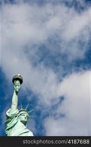 Sunnny day, blue sky with clouds: statue of Liberty with copy space