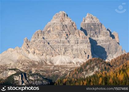 Sunny autumn alpine Dolomites mountain scene, Sudtirol, Italy. Peaceful view from Misurina environs, Monte Paterno (Three peaks of Lavaredo). Group rocky mountain tops in far.