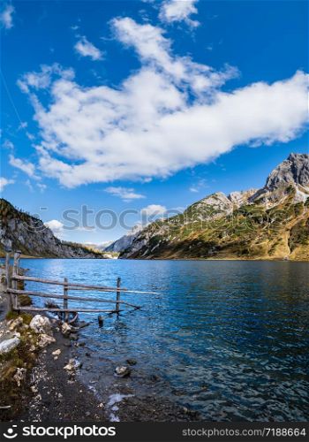 Sunny autumn alpine Tappenkarsee lake and rocky mountains above, Kleinarl, Land Salzburg, Austria. Picturesque hiking, seasonal, and nature beauty concept scene.