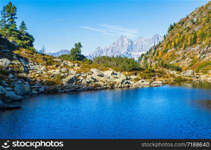 Sunny autumn alpine view. Peaceful mountain forest lake with clear transparent water and reflections. Spiegelsee or Mirror Lake, Reiteralm, Steiermark, Austria.