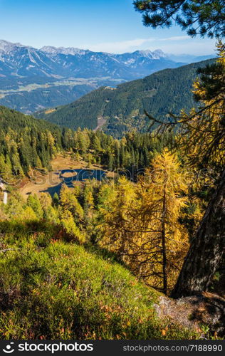 Sunny autumn alpine view. Peaceful mountain forest lake with clear transparent water and reflections. Untersee lake, Reiteralm, Steiermark, Austria.