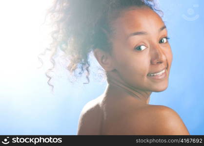 sunny beautiful mulatto laughing woman on sky background