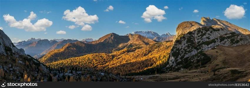 Sunny colorful autumn alpine Dolomites rocky mountain scene, Sudtirol, Italy. Peaceful view from Falzarego Pass. Snowy Marmolada massif and Glacier in far.