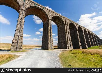 Sunny day with path up to to the sunlit arches of the Ribblehead Viaduct, landscape. North Yorkshire, Europe, England, landscape.
