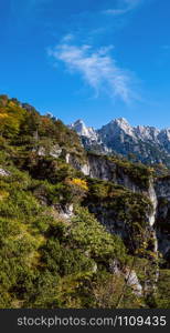 Sunny idyllic colorful autumn alpine scene. Peaceful rocky mountain view from hiking path near Almsee lake, Upper Austria.