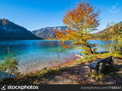 Sunny idyllic colorful autumn alpine view. Peaceful autumn Alps mountain lake with clear transparent water and reflections. Offensee lake, Salzkammergut, Upper Austria.