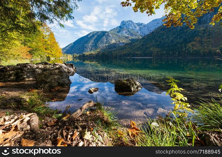 Sunny idyllic colorful autumn alpine view. Peaceful mountain lake with clear transparent water and reflections. Langbathseen lake, Upper Austria.