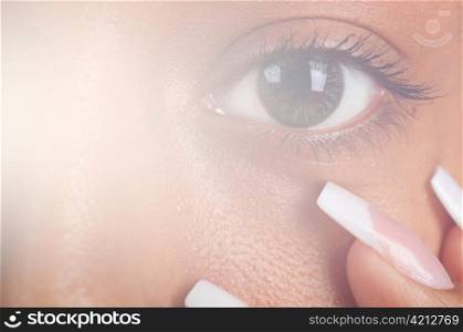 sunny macro photo of a mulatto female eye and finger nails