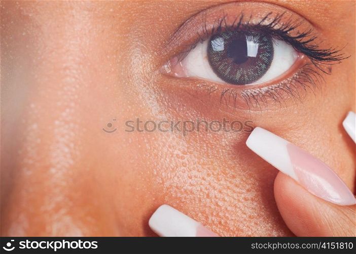 sunny macro photo of a mulatto female eye and fingers