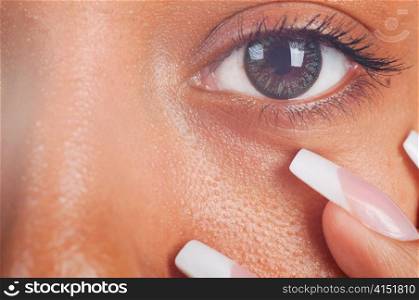 sunny macro photo of a mulatto female eye and fingers