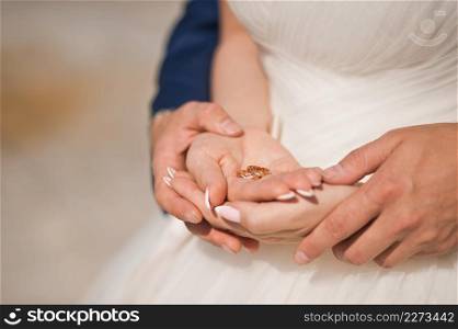 Sunny photo of the newlyweds holding hands.. Gentle embrace of the hands of the newlyweds 3938.