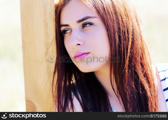 Sunny portrait of a beautiful young girl closeup.