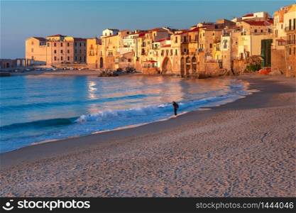 Sunny sand beach in old town of coastal city Cefalu at sunset, Sicily, Italy. Cefalu at sunset, Sicily, Italy