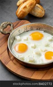 Sunny Side Up Eggs with feta cheese in a copper pan