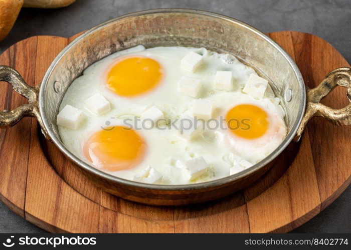 Sunny Side Up Eggs with feta cheese in a copper pan