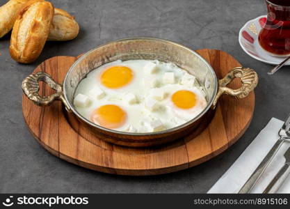 Sunny Side Up Eggs with feta cheese in a copper pan