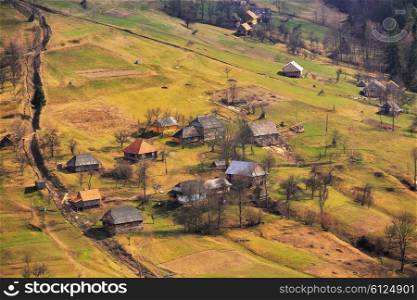 Sunny spring in mountain village. Carpathian fields and hills