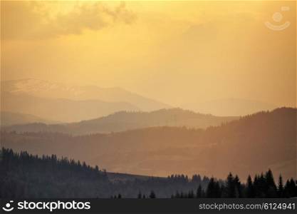 Sunny spring in mountain village. Carpathian fields and hills