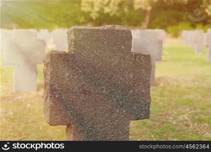 Sunny tomb with stone cross in the cementery