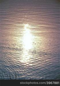 Sunrays falling on water creates a golden color feel