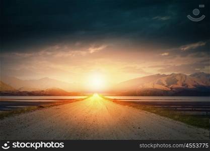 Sunrise above road. Empty asphalt road and sun rising at skyline