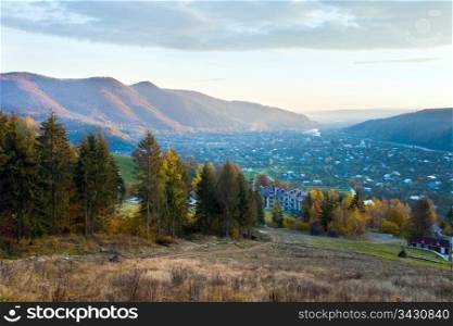 Sunrise and autumn misty mountain landscape with village in valley (Carpathian, Ukraine)