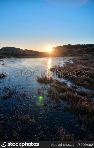 sunrise and frozen lake in national park in the Netherlands in HDR