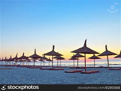 sunrise and umbrelllas on black sea beach